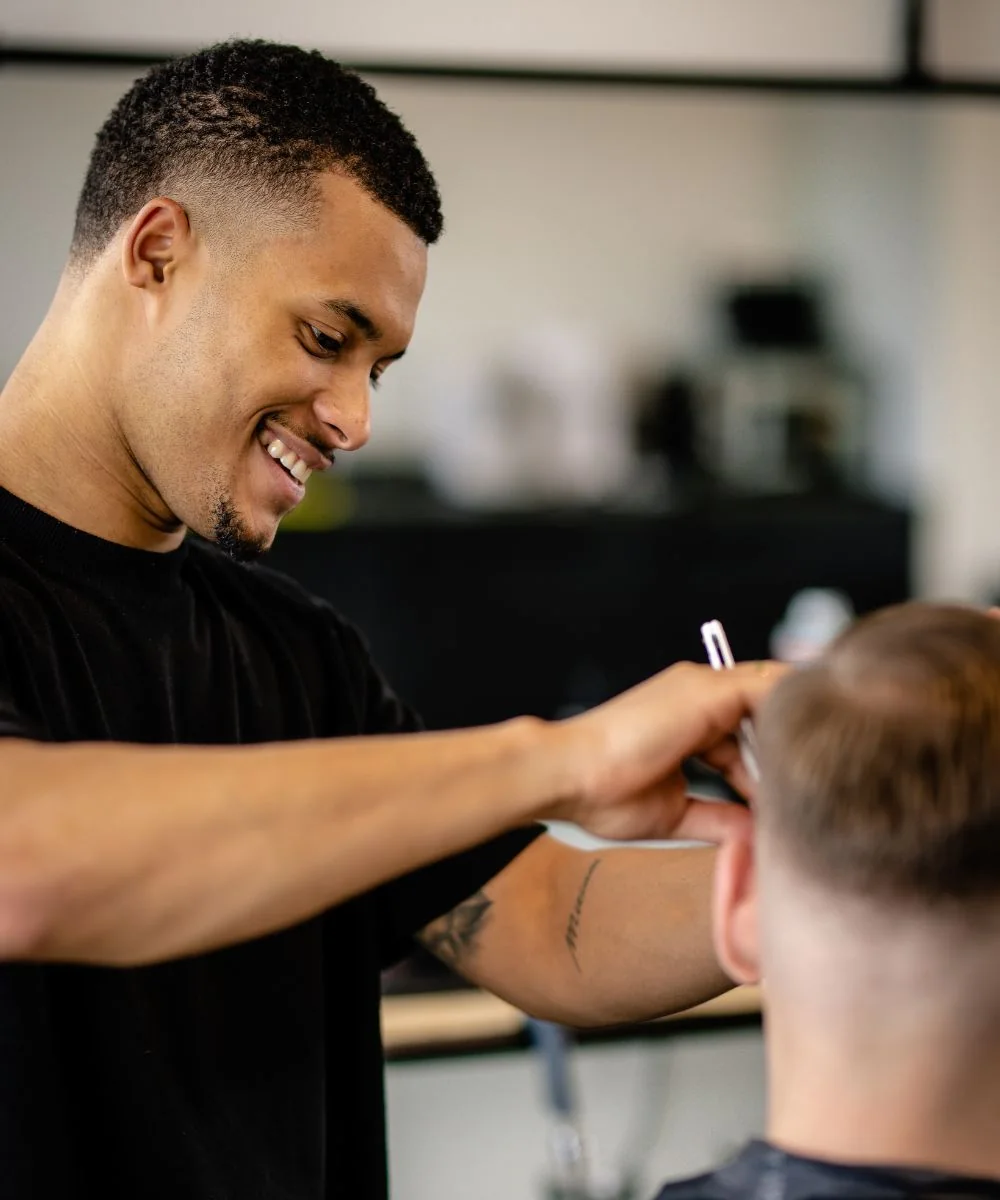Luca — senior barber, mid line-up on a client