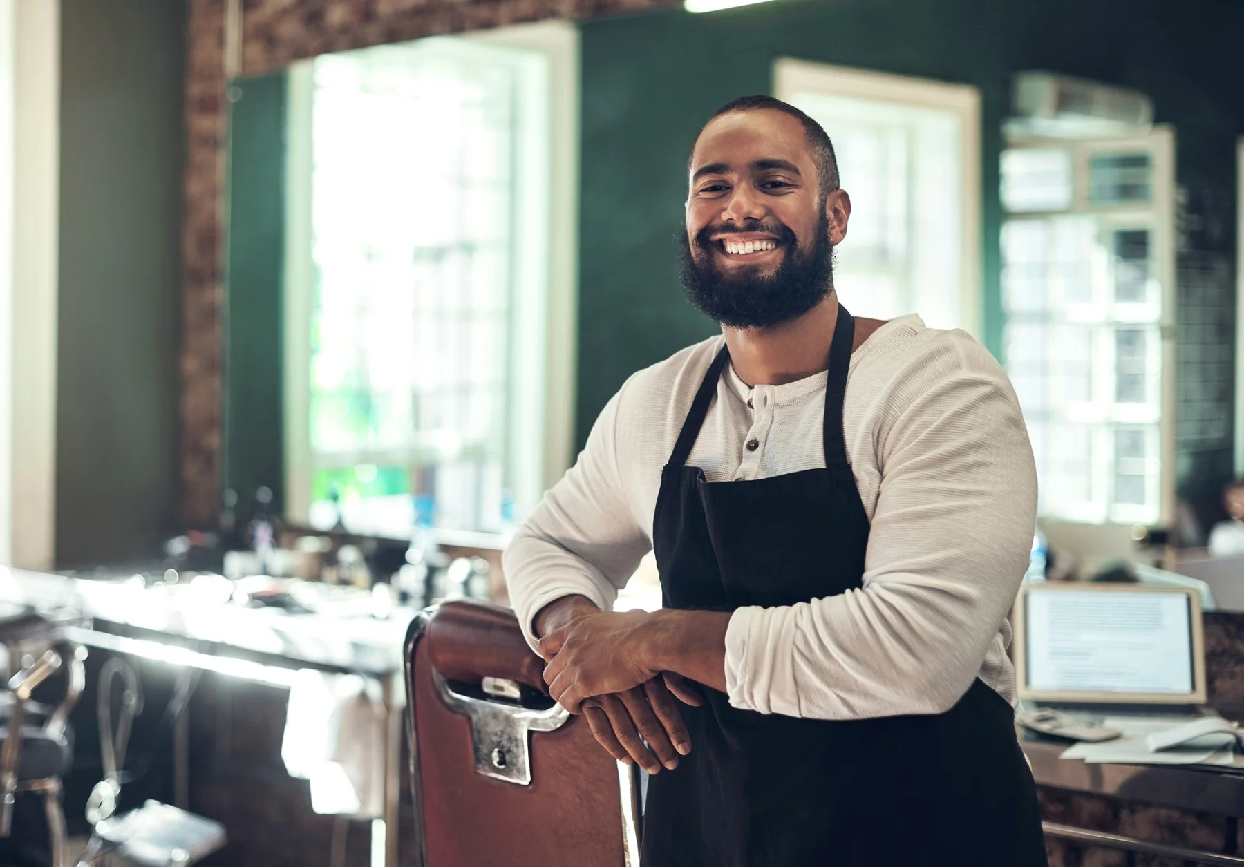 Noah — barber, leaning on a chair with a big smile